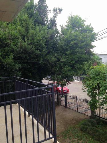 a black fence with a red car parked in a parking lot at Guest House Madonna in K'obulet'i