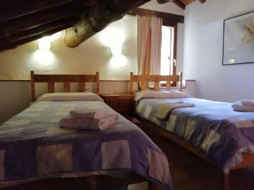 ナバレドンダ・デ・グレドスにあるCasa Rural La Pontezuela Abajoのベッド2台が隣同士に設置された部屋です。
