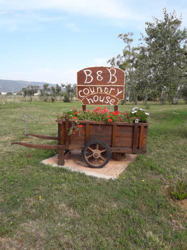 a sign for a beb comfy house in a field at B & B Country House in Capoterra