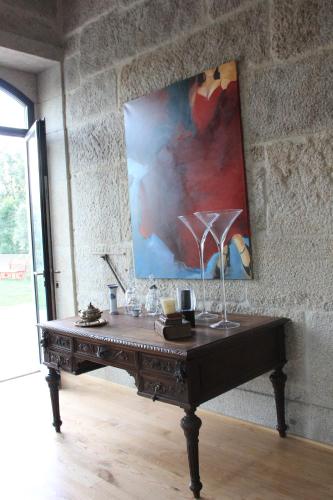a table in a room with a painting on the wall at Quinta de Fiães in Vilar de Maçada