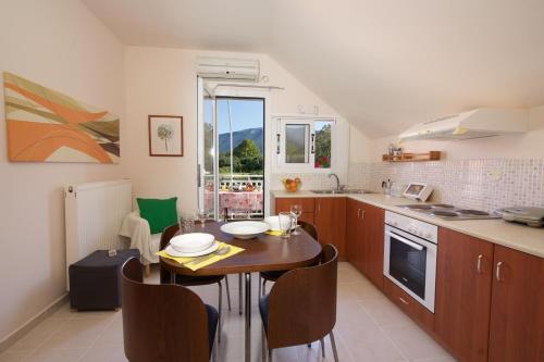 a kitchen with a table with chairs and a table and a tableablish at Christina's place in Sami