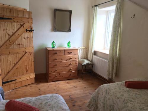 a bedroom with a dresser with a mirror and a window at Restored School Master’s House in Valentia Island