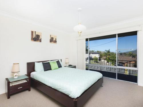 a bedroom with a bed and a large window at Capeview in Forster