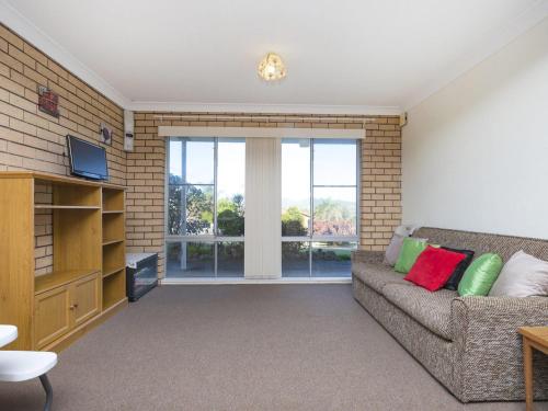a living room with a couch and a large window at Capeview in Forster