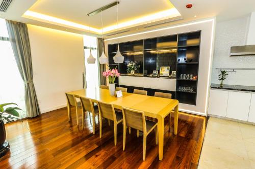 a dining room with a wooden table and chairs at HNC Premier Hotel & Residences in Hanoi