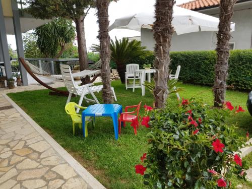 a patio with colorful chairs and a table with an umbrella at B&B LA CASA DEL CASALE in Roseto degli Abruzzi
