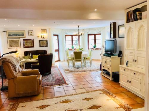 a living room with a couch and a tv at Ferienhaus Zirbe in Rickenbach