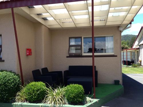 a screened in porch with chairs and a window at Lantern Court Motel in Reefton