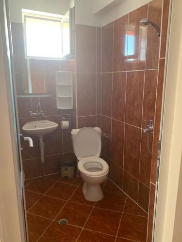 a bathroom with a toilet and a sink at Къща Нанси in Sunny Beach