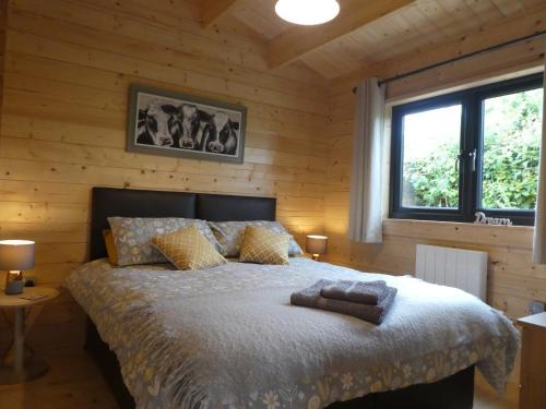 a bedroom with a bed in a wooden wall at Pound Farm Holidays - Orchard Lodge in Cullompton
