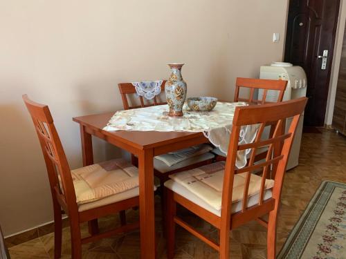 uma mesa com duas cadeiras e um vaso sobre ela em Apartment Tamara em Budva
