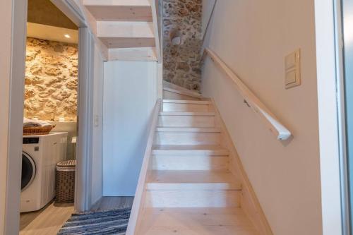 a staircase leading up to a laundry room in a house at Amelia & Nicholas Stone Houses in Doukádes