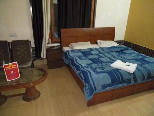 Un dormitorio con una cama y una mesa con toallas. en 2bhk Apartments near Khajjiar Lake, en Khajjiar 