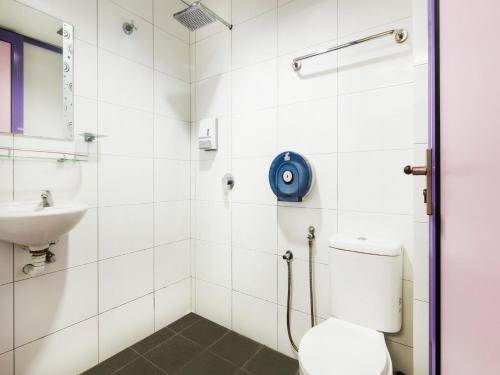 y baño con aseo y lavamanos. en OYO 880 Hotel Purple Town, en Sekinchan