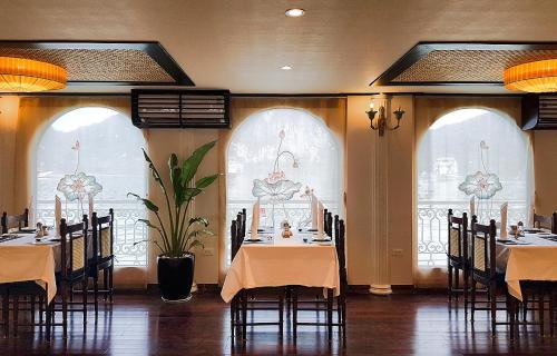 a dining room with tables and chairs and windows at Indochine Cruise Lan Ha Bay in Ha Long