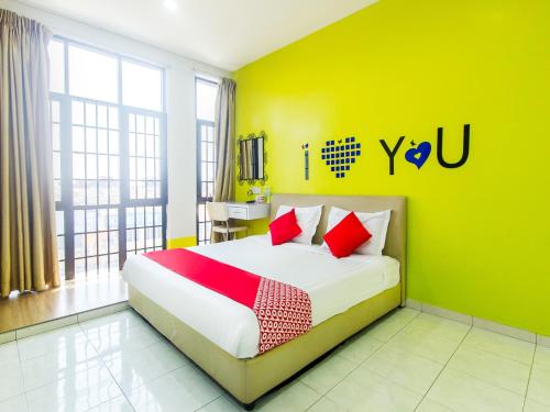 
a bedroom with a white bed and a blue wall at OYO 880 Hotel Purple Town in Sekinchan
