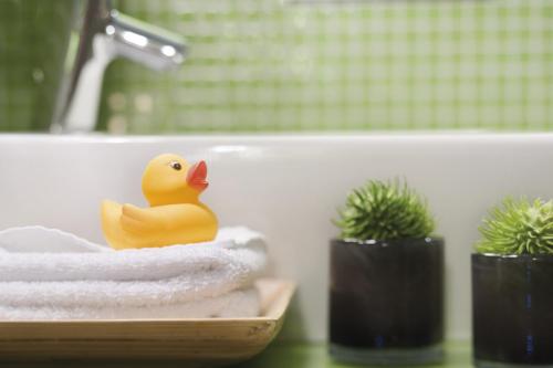 a rubber duck sitting on a pile of towels in a bathroom at Mövenpick Hotel München-Airport in Hallbergmoos