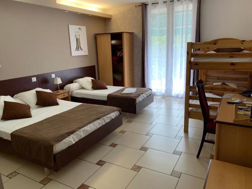 um quarto de hotel com duas camas e uma secretária e uma secretária em Hôtel restaurant Mon Auberge em Lunel