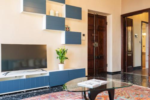 a living room with a tv and a glass table at Carlotta Flexyrent Apartment in Rapallo