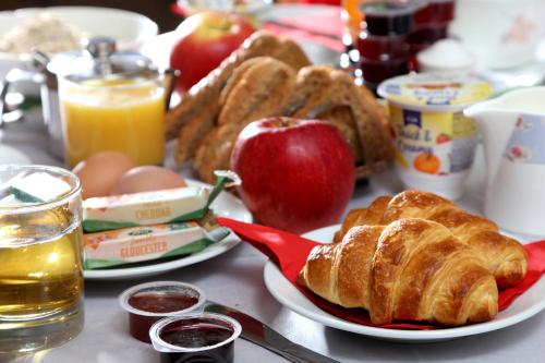 a table with a breakfast of croissants and an apple at Queensway Hotel, Sure Hotel Collection by Best Western in London