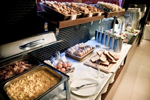 a buffet with eggs and other food on a table at Best Western Hotel Goldenmile Milan in Trezzano sul Naviglio