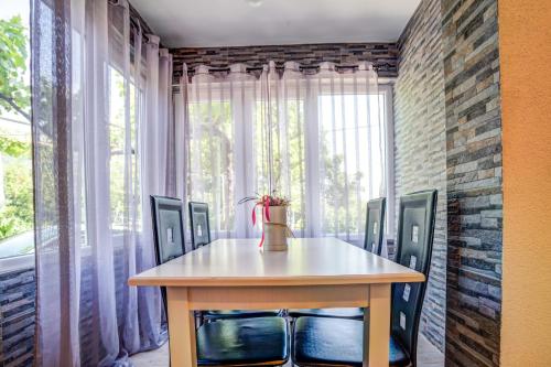 ein Esszimmer mit einem Tisch, Stühlen und einem Fenster in der Unterkunft Stojkovic Family Apartments in Tivat