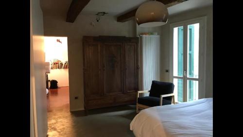1 dormitorio con 1 cama, 1 silla y 1 ventana en Casa luminosa con giardino in centro storico en Reggio Emilia