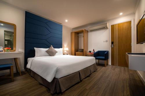 a bedroom with a large bed and a blue wall at Hanoi Backpackers Hostel & Rooftop bar in Hanoi