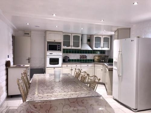 une cuisine avec une table avec des chaises et un réfrigérateur dans l'établissement Peyrascas, à Sanary-sur-Mer