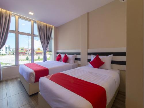 um quarto de hotel com duas camas e uma janela em Super OYO 1145 Lea Guest House & Cafe em Lukut