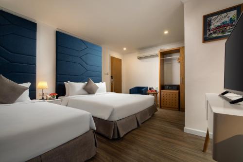 Habitación de hotel con 2 camas y TV en Hanoi Backpackers Hostel & Rooftop bar en Hanói