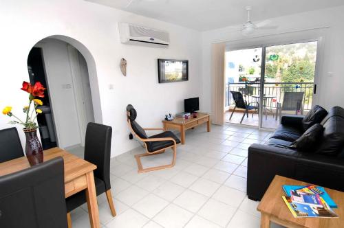 a living room with a couch and a table at Hermes Gardens in Paphos City