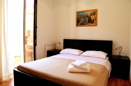 a bedroom with a bed with two towels on it at Bed & Breakfast Duomo Di Taormina in Taormina