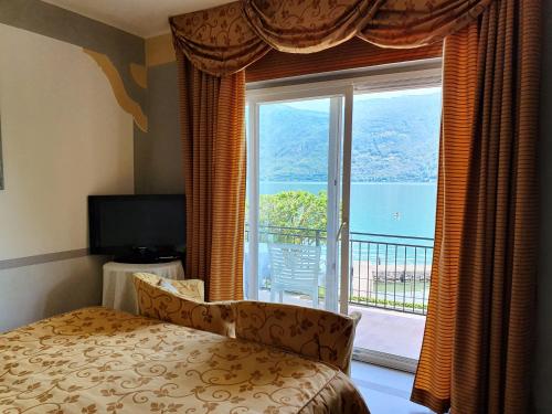 sypialnia z łóżkiem i oknem z widokiem w obiekcie Albergo Del Lago w mieście Cannobio