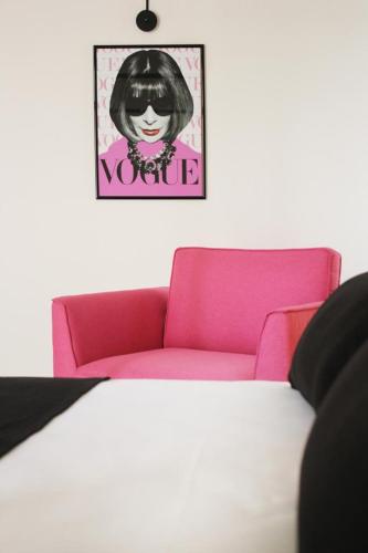 a pink couch in a room with a picture on the wall at Isabella di Castiglia Apartments in Siracusa