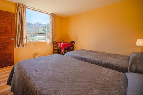 a hotel room with two beds and a window at Le Foyer Colca in Yanque