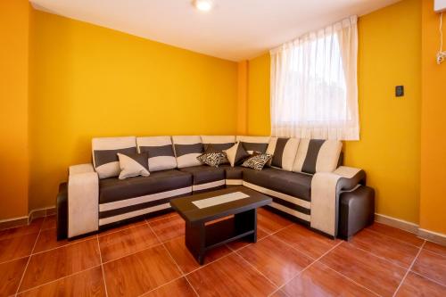 a living room with yellow walls and a couch at Le Foyer Colca in Yanque