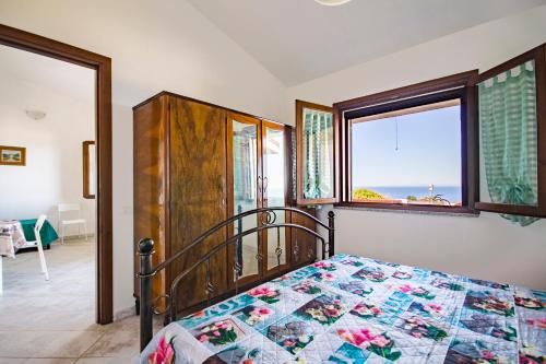 una camera con un letto con una trapunta sopra di Casa Annetta-SUPER VISTA MARE-2 camere - Giardino- Parcheggio - bbq- Wifi free-IUNP5754 a Torre Dei Corsari