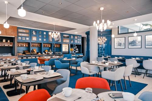 a restaurant with tables and chairs and a bar at Hôtel Mercure Toulon La Seyne-Sur-Mer in La Seyne-sur-Mer