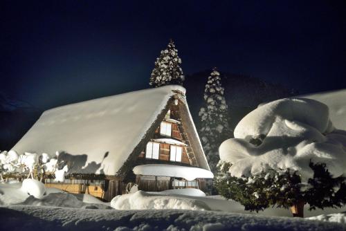 a house covered in snow with a christmas tree at Hida-Takayama Michi in Takayama