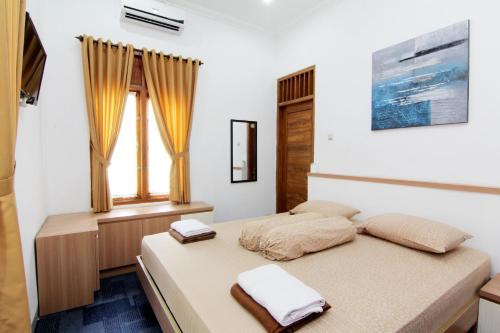 Postel nebo postele na pokoji v ubytování Embe Joglo Homestay