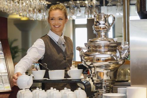 a woman standing behind a counter with a trophy at Mövenpick Hotel München-Airport in Hallbergmoos