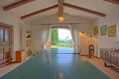 a large ping pong table in a room with a window at Villa Uccellaia by PosarelliVillas in Agello