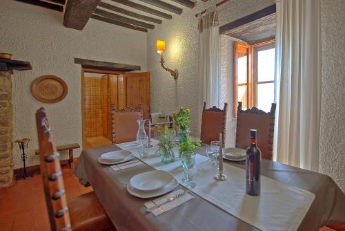 a dining room table with a bottle of wine on it at Villa Uccellaia by PosarelliVillas in Agello