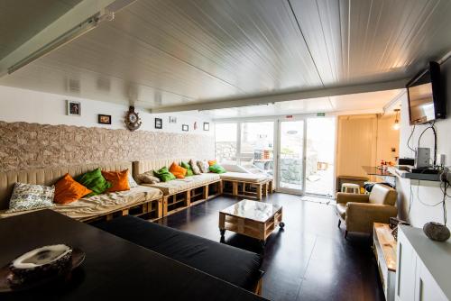 a living room with a couch with colorful pillows at Hostel & Surfcamp 55 in Ericeira