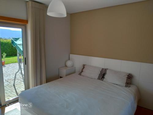 a bedroom with a bed and a sliding glass door at Casa Vilarelho in Caminha