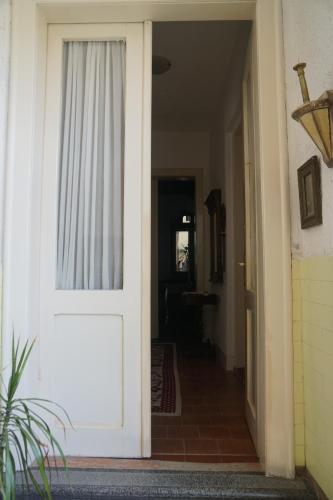 a white door with a window in a hallway at Somborski salas - strogi centar in Sombor