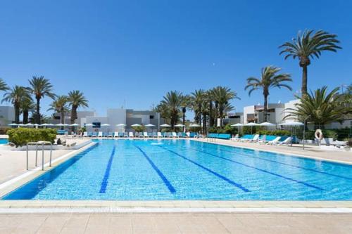 una gran piscina con palmeras en un complejo en Primavera gelijkvloers appartement met ruim terras en wifi, en Costa del Silencio