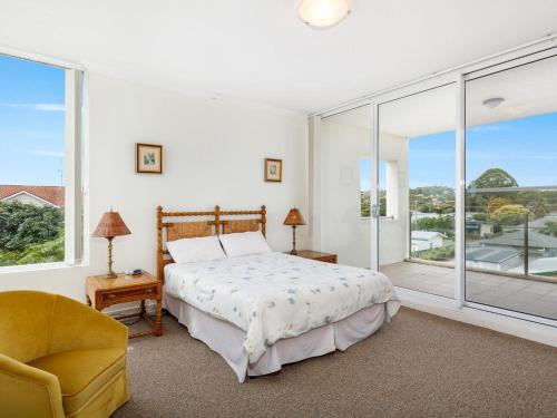 a bedroom with a bed and a large window at Regatta 13 in Forster