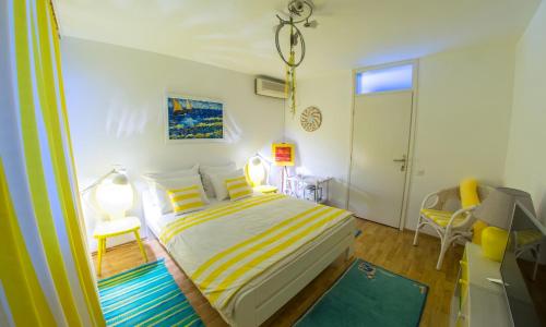 a bedroom with a bed with yellow and white stripes at Yellow Lily Mostar Apartman in Mostar